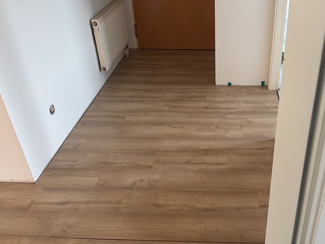 Fertig verlegter Boden in Holzoptik in einem hellen Flur