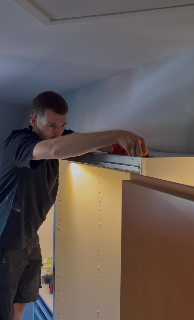 Ein Mitarbeiter von Erben & Räumen montiert einen Einbauschrank