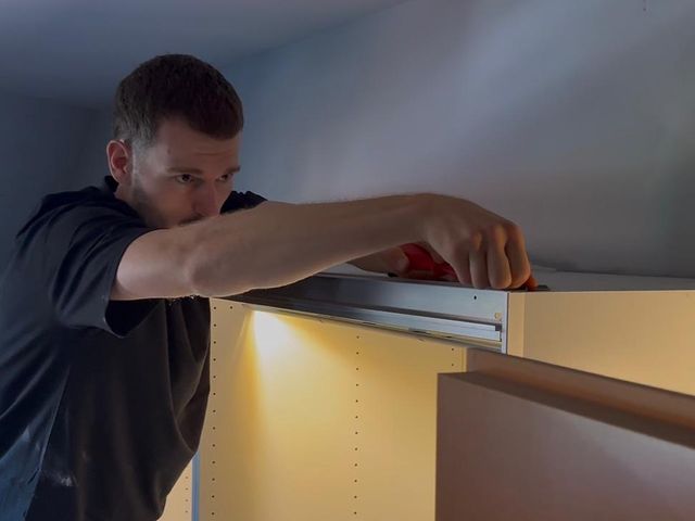 Ein Mitarbeiter von Erben & Räumen montiert einen Einbauschrank